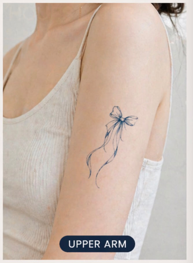 Dreamy bow temporary tattoo on chest — Alter Ego Ink fine line lasts 2 weeks