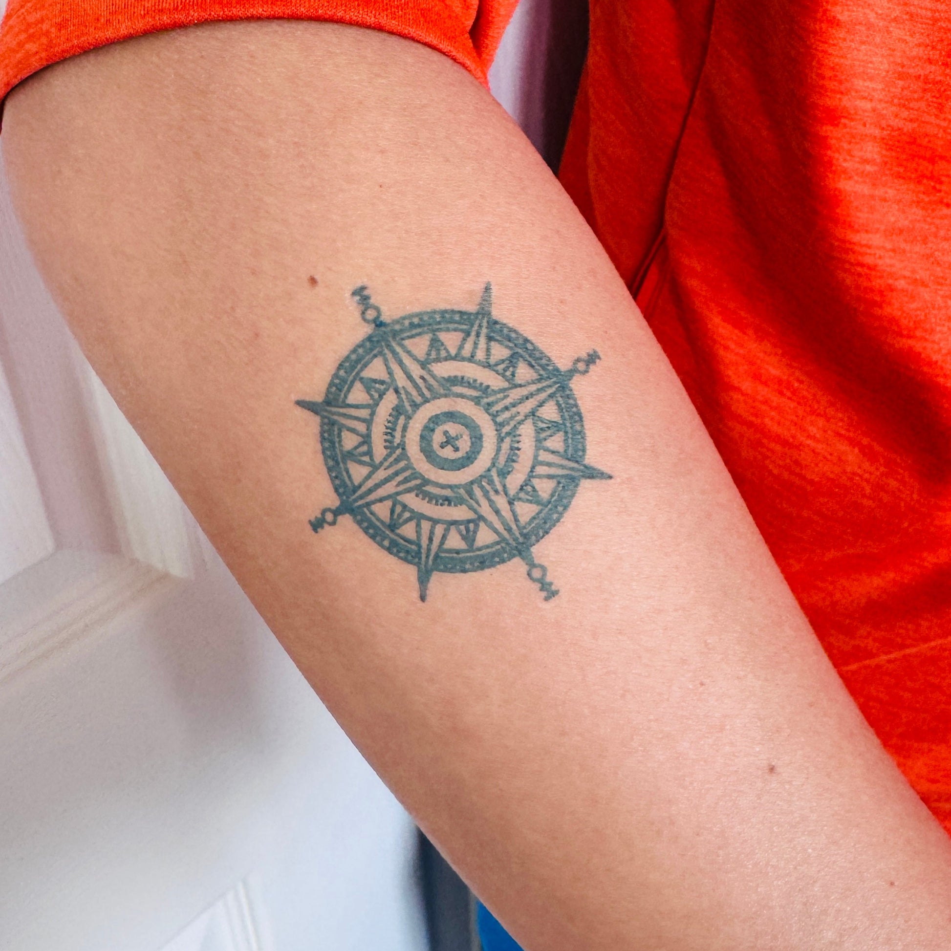 Fine line compass temporary tattoo on arm — Alter Ego Ink nautical travel tattoo design