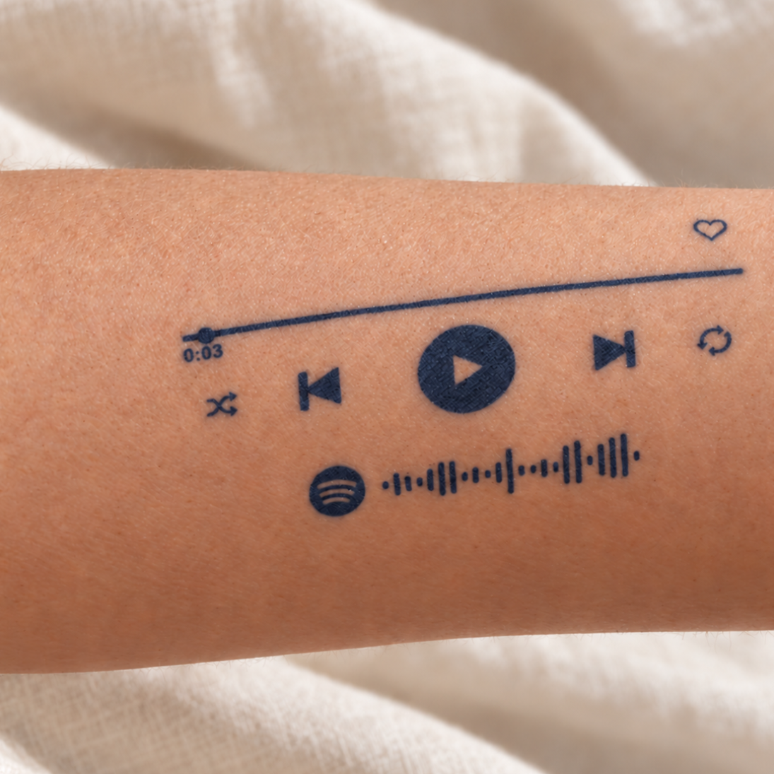Spotify music player temporary tattoo on an inner forearm, featuring playback controls, a heart and a music code
