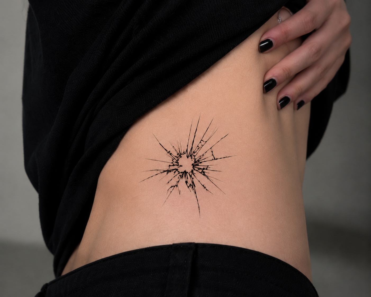 Model wearing the Breaking Point broken glass temporary tattoo on the upper arm with a realistic fine line look.