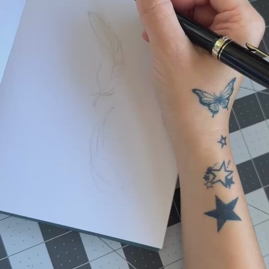 Hand-drawn Twin Feathers fine line temporary tattoo design featuring two elegant floating feathers.