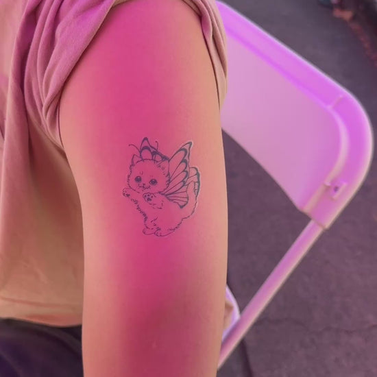 Customer showing the Butterfly Kitty fine line temporary tattoo on the arm