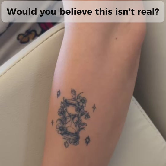 Close-up video of a woman wearing the Balance in Bloom floral hourglass water-free temporary tattoo on her forearm, highlighting its realistic fine line botanical design