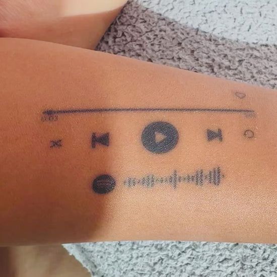 Close-up video of the On Repeat music player temporary tattoo on skin