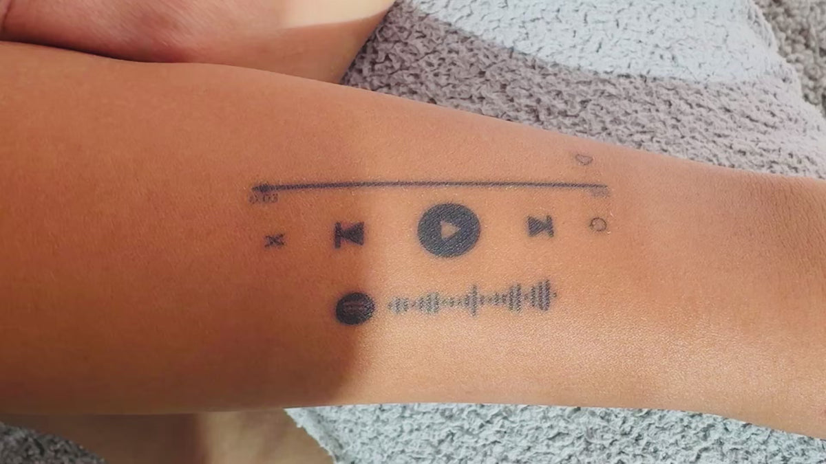Close-up video of the On Repeat music player temporary tattoo on skin